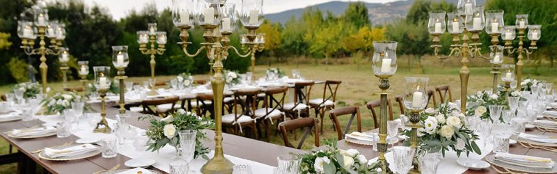 decorated-wedding-celebration-table-with-guests-seats-outdoors-gardens-with-mountain-view-min