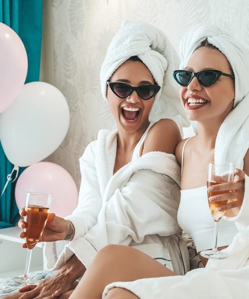 two-young-beautiful-smiling-girls-white-bathrobes-towels-head-min